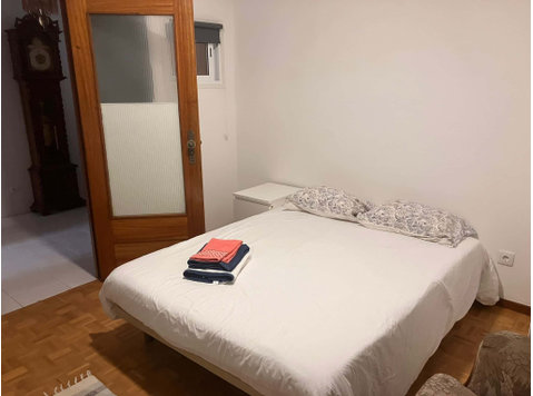 Spacious bedroom with a double bed, a desk and a couch - Appartementen