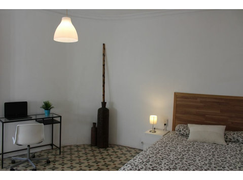 Habitación con cama doble y balcón en Ciutat Vella - Apartments