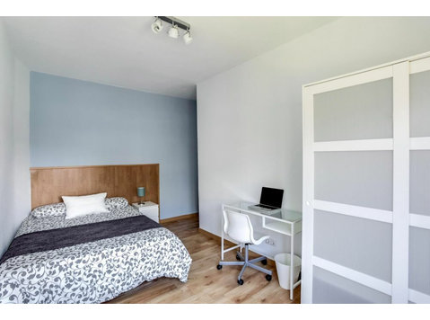 Habitación con cama doble y ventana en el Eixample - דירות